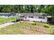 Charming single-story home with red shutters, solar panels, a carport, and fenced front yard at 801 Nw 16Th Ct, Ocala, FL 34475