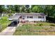 Charming single-story home with red shutters, solar panels, a carport, and fenced front yard at 801 Nw 16Th Ct, Ocala, FL 34475