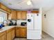 Efficient kitchen with wood cabinets, white appliances, and ample counter space at 801 Nw 16Th Ct, Ocala, FL 34475
