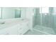 Modern bathroom featuring double sinks, white cabinets, and glass enclosed shower at 7433 Stone Creek Trl, Kissimmee, FL 34747