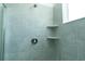 Tiled shower stall with a shower head and built-in shelving at 7433 Stone Creek Trl, Kissimmee, FL 34747