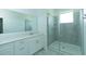 Bright bathroom featuring a large vanity with double sinks and a glass-enclosed shower at 7433 Stone Creek Trl, Kissimmee, FL 34747
