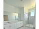 Beautiful bathroom features white double vanity, shower, and large mirror at 7433 Stone Creek Trl, Kissimmee, FL 34747
