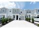 Charming townhome with white and gray exterior, attached garage, and well-maintained landscaping at 7433 Stone Creek Trl, Kissimmee, FL 34747