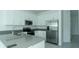 Modern kitchen featuring stainless steel appliances and bright white cabinets with gray countertops at 7433 Stone Creek Trl, Kissimmee, FL 34747