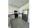 Well-lit kitchen with stainless steel appliances and ample storage in white cabinets at 7433 Stone Creek Trl, Kissimmee, FL 34747