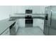 Bright kitchen featuring stainless steel appliances, white cabinets, and gray countertops at 7433 Stone Creek Trl, Kissimmee, FL 34747