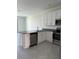 Modern kitchen boasts stainless steel appliances, island, and white cabinetry at 7433 Stone Creek Trl, Kissimmee, FL 34747