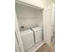 Convenient laundry room featuring a modern washer and dryer, with shelving for storage at 7433 Stone Creek Trl, Kissimmee, FL 34747