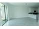 Open-concept living room with tile flooring, adjacent to the kitchen and a sliding glass door at 7433 Stone Creek Trl, Kissimmee, FL 34747
