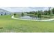 Community pond with a walking path and green space at 7433 Stone Creek Trl, Kissimmee, FL 34747