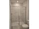 Modern bathroom with white marble style tiles, glass shower doors, and contemporary fixtures at 2453 Magnolia Reserve Rd, Ocoee, FL 34761