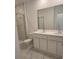 Bathroom featuring double sinks, shower with glass door, white cabinets and modern finishes at 2453 Magnolia Reserve Rd, Ocoee, FL 34761
