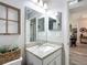 Neutral-toned bathroom with granite countertops, decorative mirror, and view into hallway at 12396 Sw 64Th Street Rd, Ocala, FL 34481