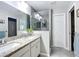 Bright primary bathroom with double vanity, glass enclosed shower, and neutral tile at 12396 Sw 64Th Street Rd, Ocala, FL 34481
