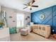 bedroom with a blue accent wall, wood laminate flooring, and a custom surfboard at 12396 Sw 64Th Street Rd, Ocala, FL 34481