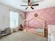 bedroom with a pink accent wall, wood laminate flooring, and a house-shaped bed frame at 12396 Sw 64Th Street Rd, Ocala, FL 34481