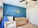 Charming Bedroom featuring a geometric accent wall and cozy rocking chair at 12396 Sw 64Th Street Rd, Ocala, FL 34481