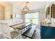 Dining room with an ornate chandelier, a long dark wood table, a bench, and stylish decor at 12396 Sw 64Th Street Rd, Ocala, FL 34481