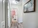 Hallway featuring wood laminate flooring and view of a bedroom with a custom accent wall at 12396 Sw 64Th Street Rd, Ocala, FL 34481