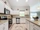 Well-lit kitchen featuring granite countertops, white cabinetry, stainless steel appliances and ample space at 12396 Sw 64Th Street Rd, Ocala, FL 34481