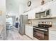 Modern kitchen with stainless steel appliances, granite countertops, and seamless flow to dining area at 12396 Sw 64Th Street Rd, Ocala, FL 34481