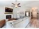 Spacious living room features a stone fireplace, ceiling fan, and wood laminate flooring at 12396 Sw 64Th Street Rd, Ocala, FL 34481