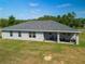 Back of house with patio seating offers a peaceful place to relax and enjoy outdoors at 12396 Sw 64Th Street Rd, Ocala, FL 34481