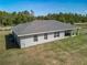 Grey house rear view featuring patio with seating, well-manicured lawn and new roof at 12396 Sw 64Th Street Rd, Ocala, FL 34481