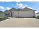 This home features an attached two-car garage, a large driveway, and manicured landscaping at 3315 Dzuro Dr, Oxford, FL 34484