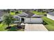 Attractive home with two-car garage, manicured lawn, and tidy landscaping at 3315 Dzuro Dr, Oxford, FL 34484