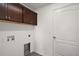 This light and bright laundry room includes upper cabinets and white door at 3315 Dzuro Dr, Oxford, FL 34484