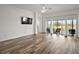Open-concept living room showcasing wood floors and sliders to backyard at 3315 Dzuro Dr, Oxford, FL 34484