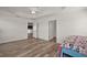 Spacious main bedroom showcasing wood floors and an open doorway to the kitchen at 3315 Dzuro Dr, Oxford, FL 34484