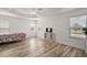Well-lit main bedroom featuring a tray ceiling, wood floors, and large windows at 3315 Dzuro Dr, Oxford, FL 34484