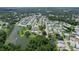 Wide aerial shot showcasing a community near a lake, surrounded by dense trees at 4856 Colonnades W Cir, Lakeland, FL 33811