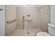 Updated shower space featuring neutral tile, safety grab bars, and a sleek, modern shower fixture at 4856 Colonnades W Cir, Lakeland, FL 33811