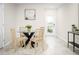 Bright dining area features a glass-top table, modern decor, and a view of the entryway at 1196 Port Blue Way, Lady Lake, FL 32159