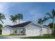 Charming single-story home featuring a two-car garage, well-manicured lawn, and lush tropical landscaping at 1252 Turtle Island Rd, Lady Lake, FL 32159