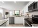 Bright kitchen featuring stainless steel appliances, white cabinets, and granite countertops at 2307 Incandescent Way, South Daytona, FL 32119