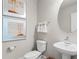 This half bath features a pedestal sink, round mirror, and decorative artwork, showcasing simple elegance at 3311 Grande Heron Dr, St Cloud, FL 34773