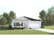 Charming single-story home with a well-maintained lawn and a two-car garage at 443 Hammock Oaks Blvd, Lady Lake, FL 32159