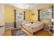Bright bedroom with sunny yellow walls, and hardwood floors creating a warm, cheerful ambiance at 4851 Ne 7Th St, Ocala, FL 34470