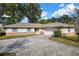 Charming one-story home with a well-maintained lawn, a long driveway, and a two-car garage at 4851 Ne 7Th St, Ocala, FL 34470