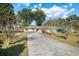 Charming one-story home with a well-maintained lawn, a long driveway, and a two-car garage at 4851 Ne 7Th St, Ocala, FL 34470