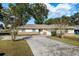 Charming one-story home with a well-maintained lawn, a long driveway, and a two-car garage at 4851 Ne 7Th St, Ocala, FL 34470
