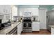 Bright kitchen featuring granite counters, stainless steel appliances and white cabinets at 4851 Ne 7Th St, Ocala, FL 34470