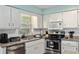 Bright kitchen featuring granite counters, stainless steel appliances and white cabinets at 4851 Ne 7Th St, Ocala, FL 34470
