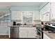 Bright kitchen featuring granite counters, stainless steel appliances and white cabinets at 4851 Ne 7Th St, Ocala, FL 34470