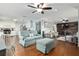 Spacious living room showcasing wood floors, blue sofa, and connecting to kitchen and den at 4851 Ne 7Th St, Ocala, FL 34470